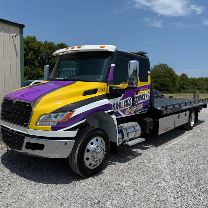 Sadler's Towing purple and gold rollback tow truck